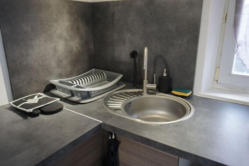 un comptoir de cuisine avec un évier et un fouet dans l'établissement Studio Cosy proche gare, à Saint-Quentin