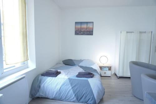 une chambre avec un lit avec des serviettes dessus dans l'établissement Studio Cosy proche gare, à Saint-Quentin