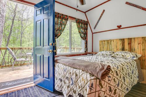 ein Schlafzimmer mit einem Bett und einem Balkon in der Unterkunft Inviting Des Arc Cabin with Fire Pit and Deck! 