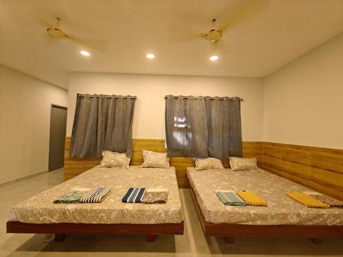 Duas camas num quarto com cortinas em HOMESTAY - AC 5 BHK NEAR AlRPORT em Chennai