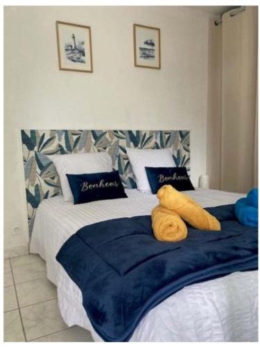 - une chambre avec 2 lits dotés d'oreillers bleus et blancs dans l'établissement A 2 pas de la plage de la Vallières, à Saint-Georges-de-Didonne