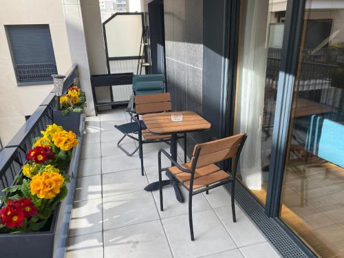 uma fila de cadeiras e mesas numa varanda com flores em Sérénité totale : appartement ensoleillé em Clichy