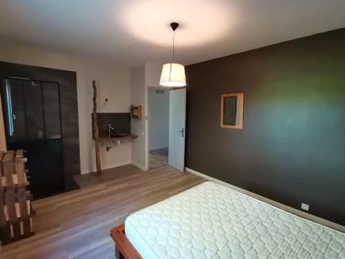 - une chambre avec un lit et un mur noir dans l'établissement les mimosas, à Ruoms