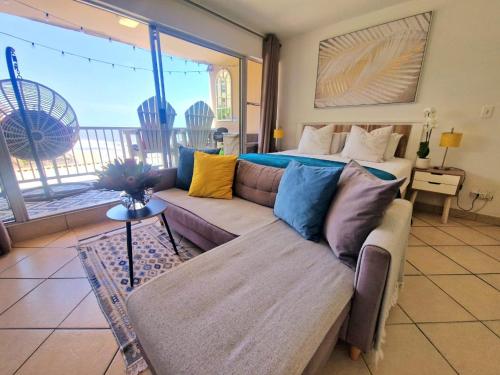 a living room with a couch and a bed at OCEAN WHISPER II - Power back up, Sea facing, Umdloti in Umdloti