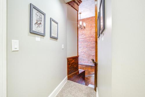 a hallway leading to a bathroom with a brick wall at Chic Derby Square Condo in the Heart of Salem! in Salem