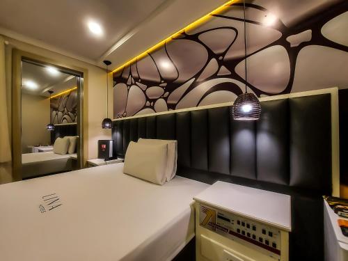 a bedroom with a large white bed and a mirror at Adrenalina Motel Itaquera - Arena Corinthians in Sao Paulo