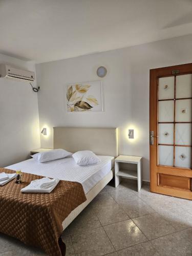 a bedroom with a bed and a table and a door at Villa Mugur in 2 Mai