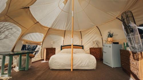 ein Schlafzimmer mit einem Bett in einem Zelt in der Unterkunft @alasaguas in San José de Maipo