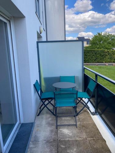 a table and chairs on a balcony with a white screen at Appartement Saint Jo in Nantes