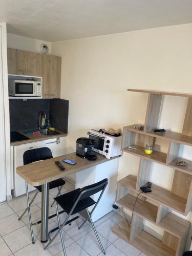 une cuisine avec une table et des chaises et un micro-ondes dans l'établissement Studio avec place de parking à la timone, à Marseille
