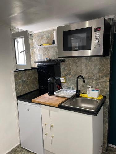 a small kitchen with a sink and a microwave at Studio fonctionnel & central proche paris in Villeneuve-Saint-Georges