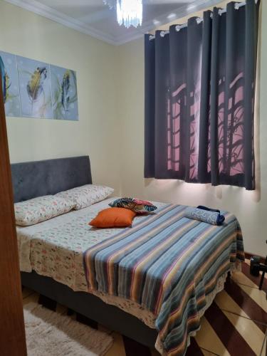 a bedroom with a bed with a colorful blanket on it at Seu Cantin em BH Venda Nova in Belo Horizonte