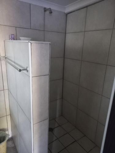 a shower with a glass door in a bathroom at Eloff's Guest House in Polokwane