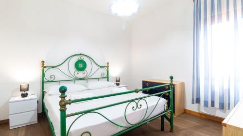 Un dormitorio con una cama verde y blanca y una ventana en Villa Caterina, en Santa Caterina