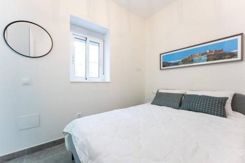 a white bedroom with a bed and a mirror at Apartamento para 4 personas en centro historico de Almeria in Almería