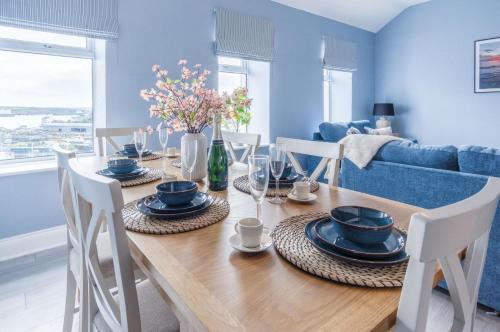 a dining room with a wooden table and chairs at Harbour Heights - 2 Bed Apartment - Milford Haven in Milford Haven