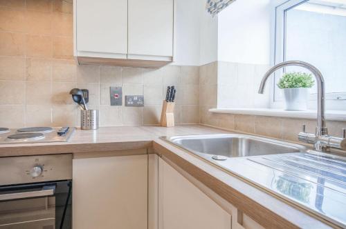 uma cozinha com um lavatório e uma janela em Harbour Heights - 2 Bed Apartment - Milford Haven em Milford Haven