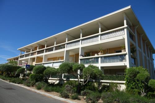 un grand bâtiment blanc avec des arbres devant lui dans l'établissement Hibiscus, à Cannes