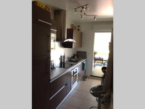 La cuisine est équipée d'un réfrigérateur noir et d'un évier. dans l'établissement Hibiscus, à Cannes