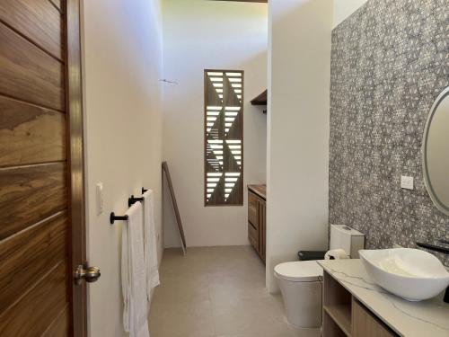 a bathroom with a toilet and a sink at Casa Cacao in Talamanca