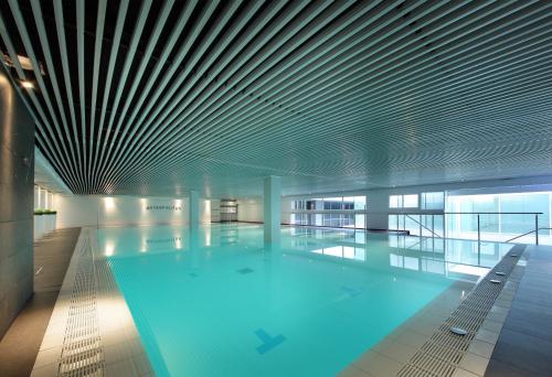 a large swimming pool in a building with a ceiling at Hesperia Sevilla in Seville