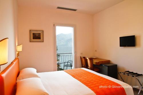 ein Hotelzimmer mit einem Bett und einem Fenster in der Unterkunft Garden Rooms 2 in Menaggio
