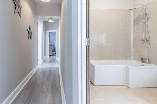 bagno bianco con vasca e doccia di Beach Haven Hideout - 2 Bedroom - Milford Haven a Milford Haven