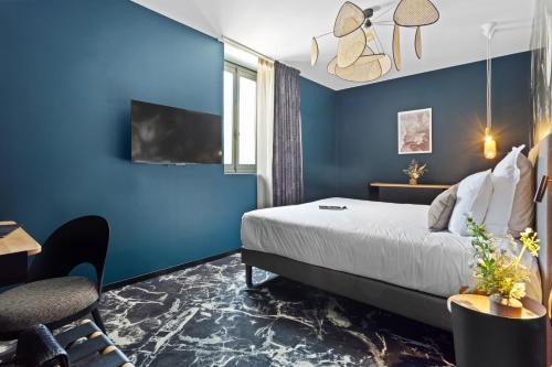 a hotel room with blue walls and a bed at LE RITUEL HOTEL & SPA in Honfleur