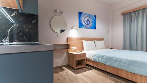 a small room with a bed and a sink at Nicole Rooms in Palaiochóra