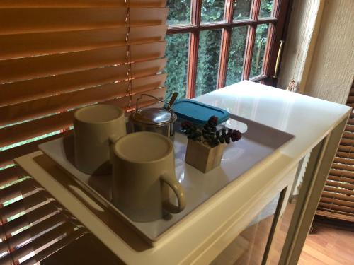 a counter with three coffee mugs on top of it at Airbnb at Bailyes in Pretoria