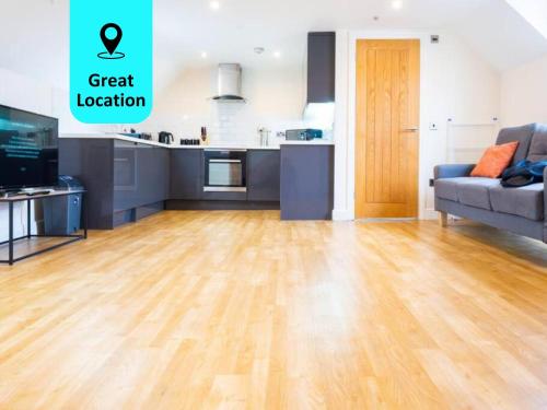 a kitchen and a living room with a hard wood floor at Charlotte House - The Stylish Sanctuary in Central Ipswich in Ipswich