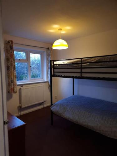 a bedroom with a bunk bed and a window at Home in Kington St Michael in Stanton Saint Quintin