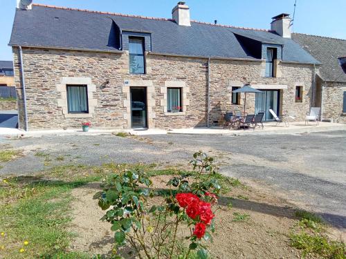 a brick house with red roses in front of it at SEJOURNER CHEZ CHANTAL in Pluherlin