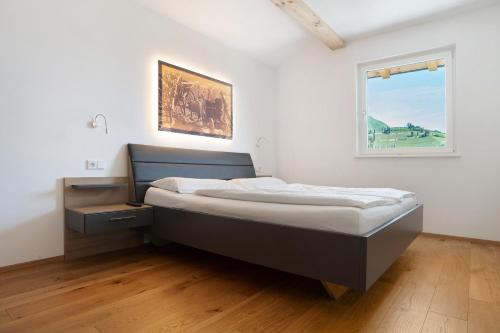 una camera con letto e finestra di Bacchushof Apartment Sauvignon a Termeno