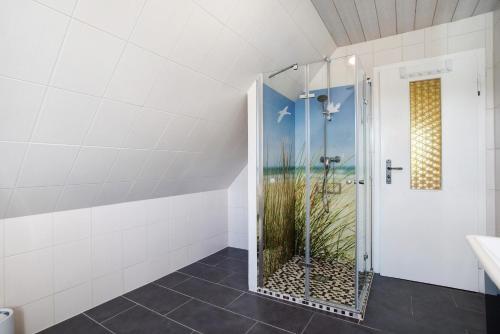 a shower with a glass door in a bathroom at Rügenferienhaus eg und og in Schaprode