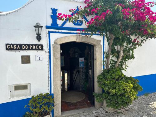 an entrance to a blue and white building with flowers at Casa do Poço in Óbidos
