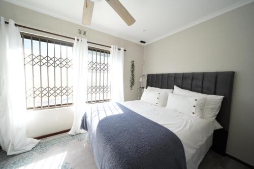 a bedroom with a bed with a large window at The Dahlia in Cape Town