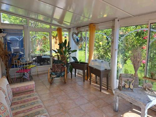 a conservatory with a room with windows and a table at La maison de Caroline in La Rochelle