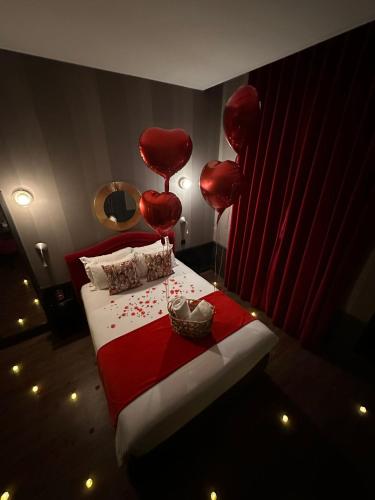 a room with a bed with red balloons on it at Alexandra in Lyon