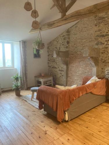 une chambre avec un lit et un mur de briques dans l'établissement Premier étage d une jolie maison à la campagne, à Montravers