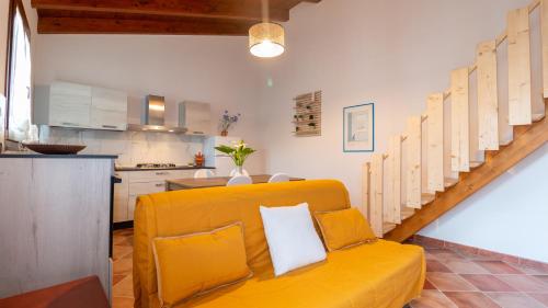 un soggiorno con divano giallo e una cucina di Welcomely - Domo Mea Apartment a Càbras