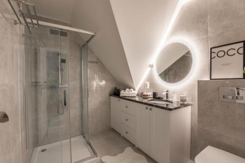 a white bathroom with a shower and a sink at Opera apartments in Banská Štiavnica