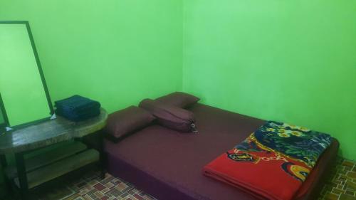 um pequeno quarto com uma cama e um espelho em Wisma PO'ONG em Ruteng