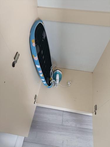 a surfboard hanging on a wall in a room at Greenwich City Staycation in Plumstead
