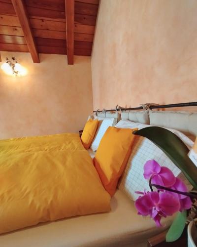 a bedroom with a bed with yellow sheets and purple flowers at Casa Liliana in Terrabona