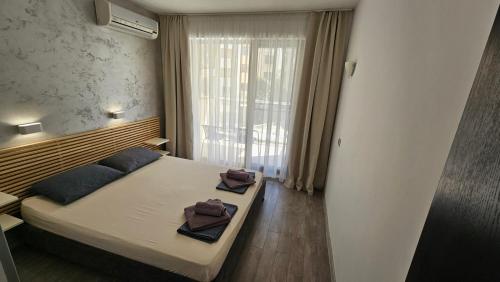 a bedroom with a bed with two towels on it at Horizont Apartment Sozopol in Sozopol