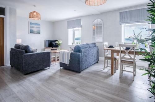 a living room with two chairs and a table at Haven View - 2 Bedroom Apartment - Milford Haven in Milford Haven