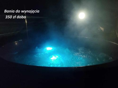 d'un bain à remous avec de l'eau bleue et un éclairage de rue. dans l'établissement Pokoje z łazienkami nad Jeziorem Serwy, à Mołowiste