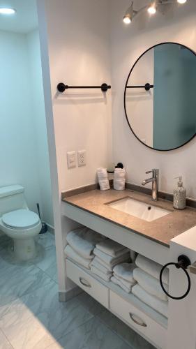 a bathroom with a sink and a mirror and a toilet at Presidential Suite in Cabo San Lucas