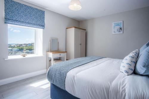 a white bedroom with a bed and a window at Haven View - 2 Bedroom Apartment - Milford Haven in Milford Haven